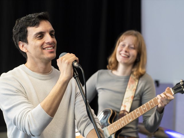 ein Sänger und eine Gitaristin während der Probe