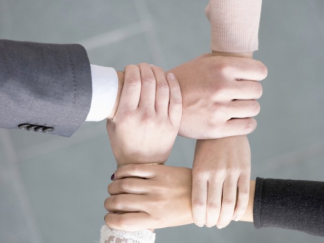 Vier Hände umfassen sich