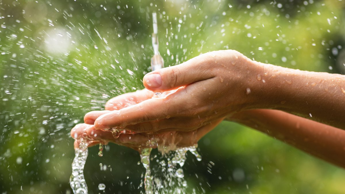 Wasser läuft in Hände unter einem Wasserhahn