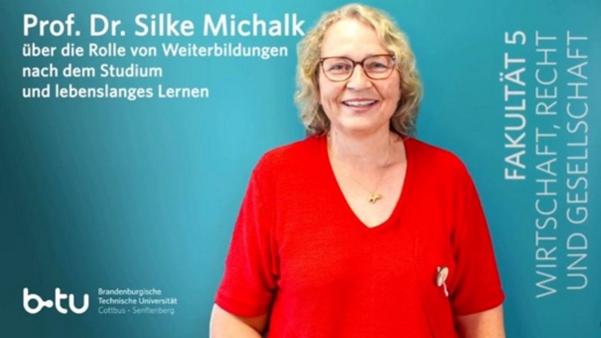 Prof- Michalk im Porträt vor dem Namenszug der Fakultät