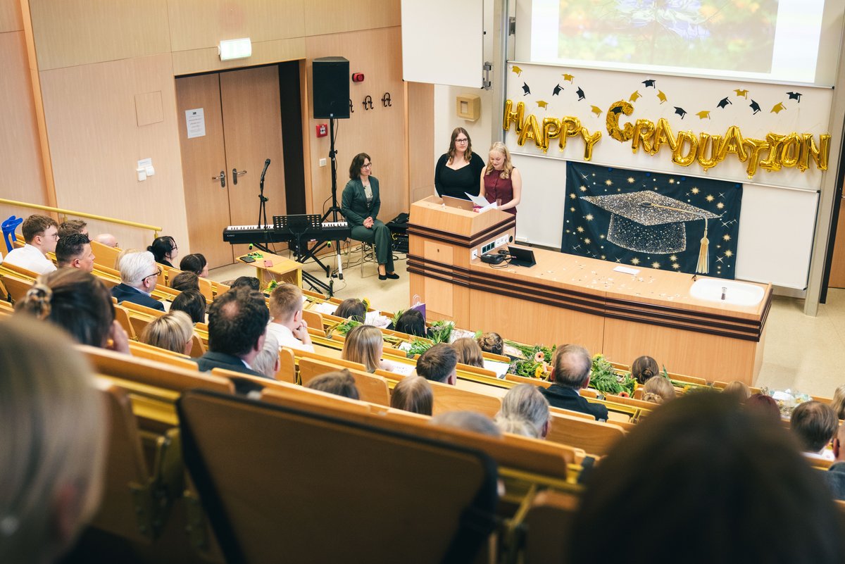 Hörsaal mit Studierenden am Rednerpult