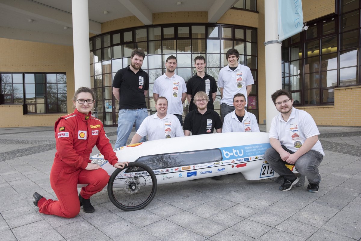 Die Studierenden vom Team Lausitz Dynamics vor dem Konrad-Zuse-Medienzentrum mit ihrem selbst konstruierten Energiesparmobil.