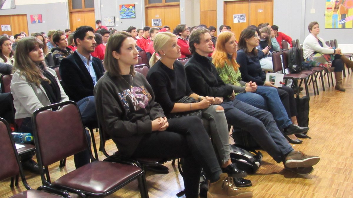 BTU-Alumna Maria-Andreea Ciurci sitzt zusammen mit anderen Personen in einem Vortragssaal