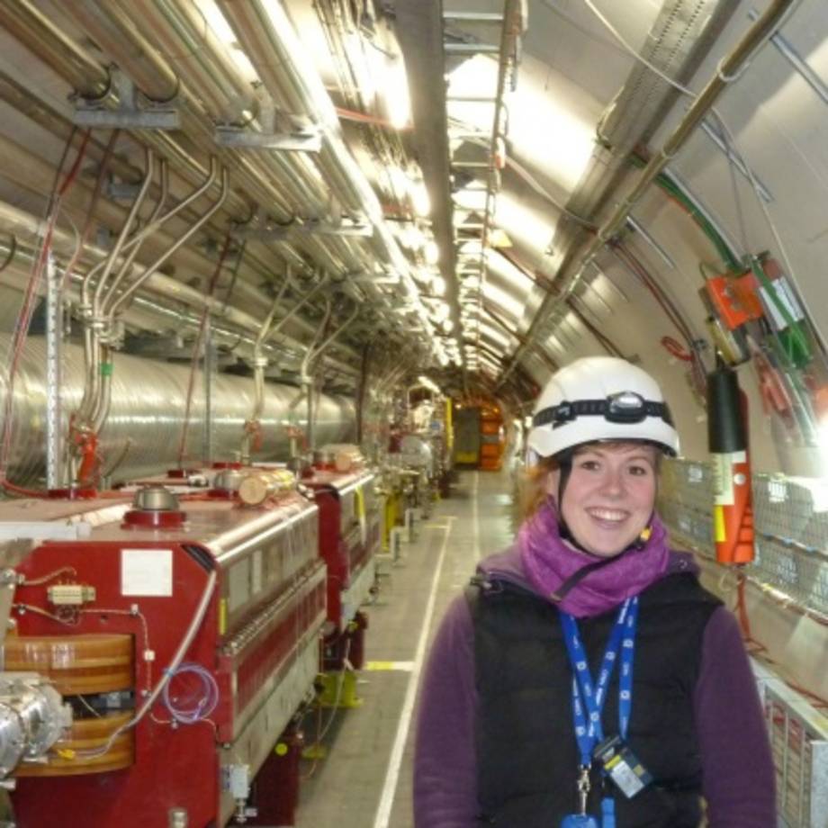 Physikalumna Maria Hempel vor Forschungsaufbau im CERN