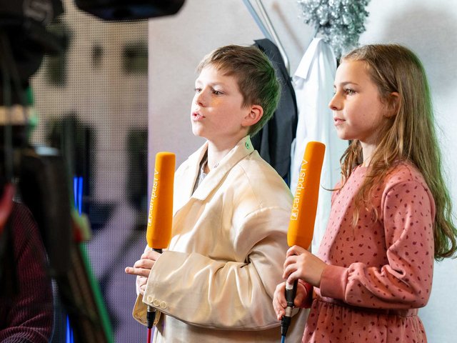 Kinder halten einen Mikrofon in die Hände fest