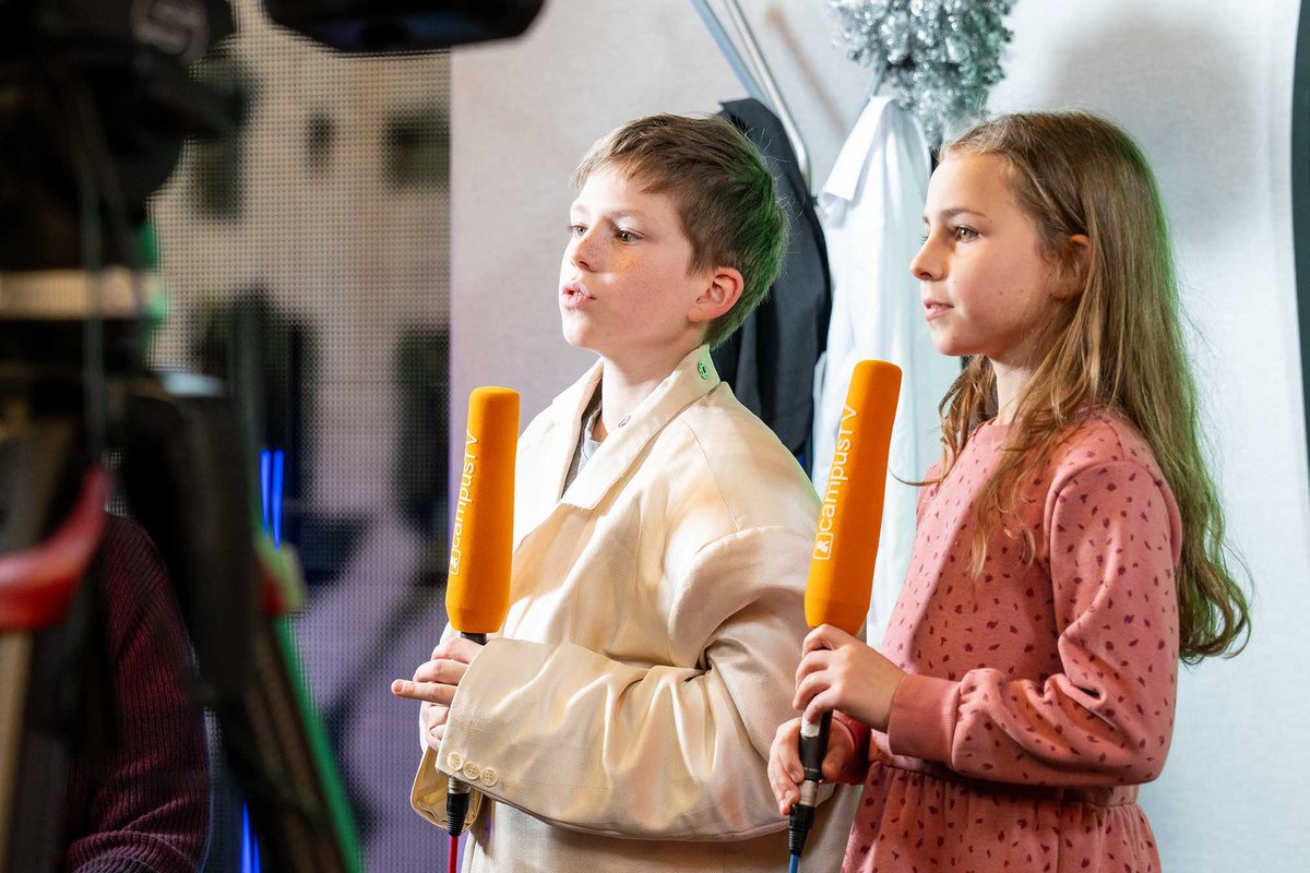 Kinder halten einen Mikrofon in die Hände fest