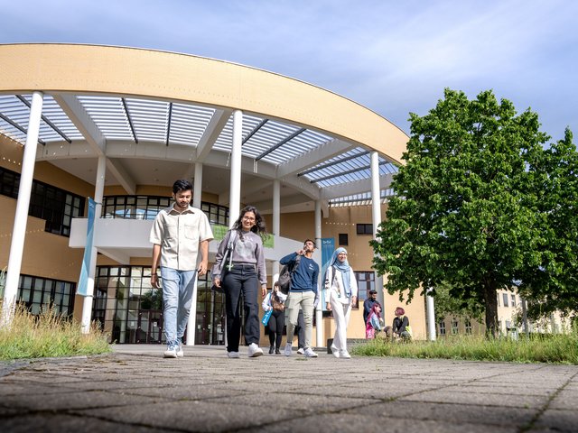Studierende laufen über den Campus 