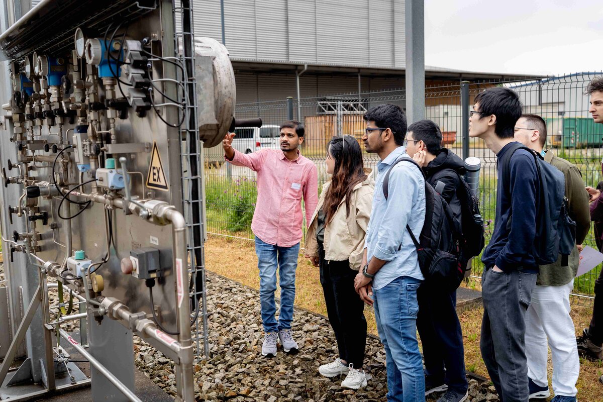 Internationale Nachwuchswissenschaftler*innen an einer Energieanlage.