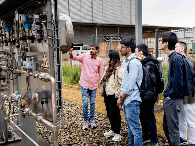 Internationale Nachwuchswissenschaftler*innen an einer Energieanlage.