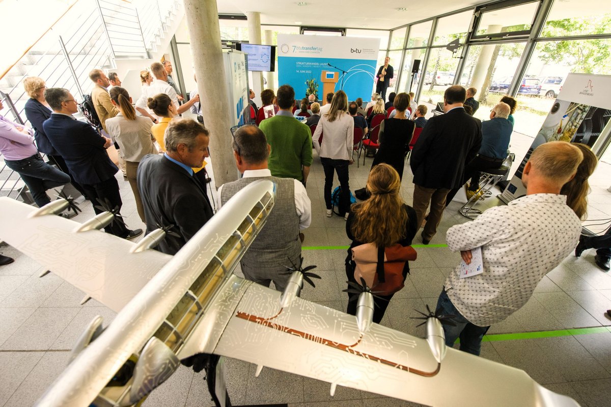 Participants of the 7th BTU Transfer Day 2022 at a lecture, in the foreground an airplane model.