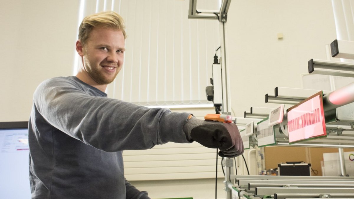 Student im Bachelor Studiengang Wirtschaftsingenieurwesen scannt mit einem Scan-Handschuh Label in der Modellfabrik