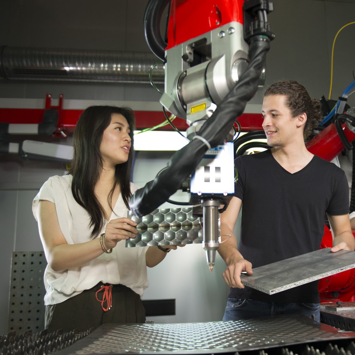 zwei Personen an der Lasermaschine, die ein Produkt schneiden wollen