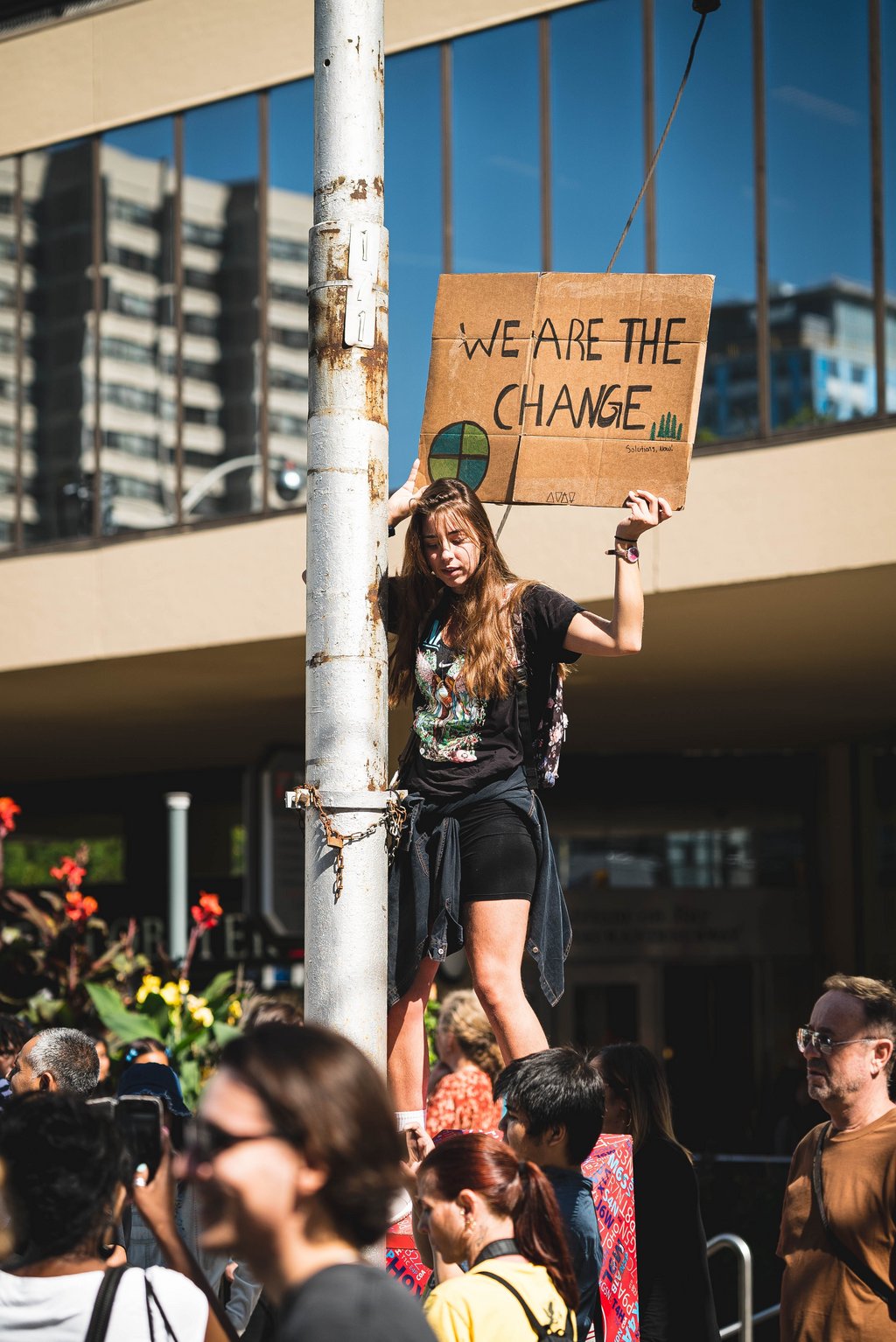 Poster der öffentlichen Ringvorlesung zur Klima- und Nachhltigkeitskrise mit jungen Menschen bei einer Protestkundgebung. Foto: Lewis Parsons/ Unsplash 