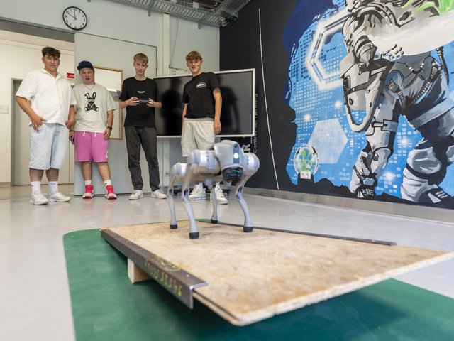 Schüler steuern Robohund über eine Wippe.