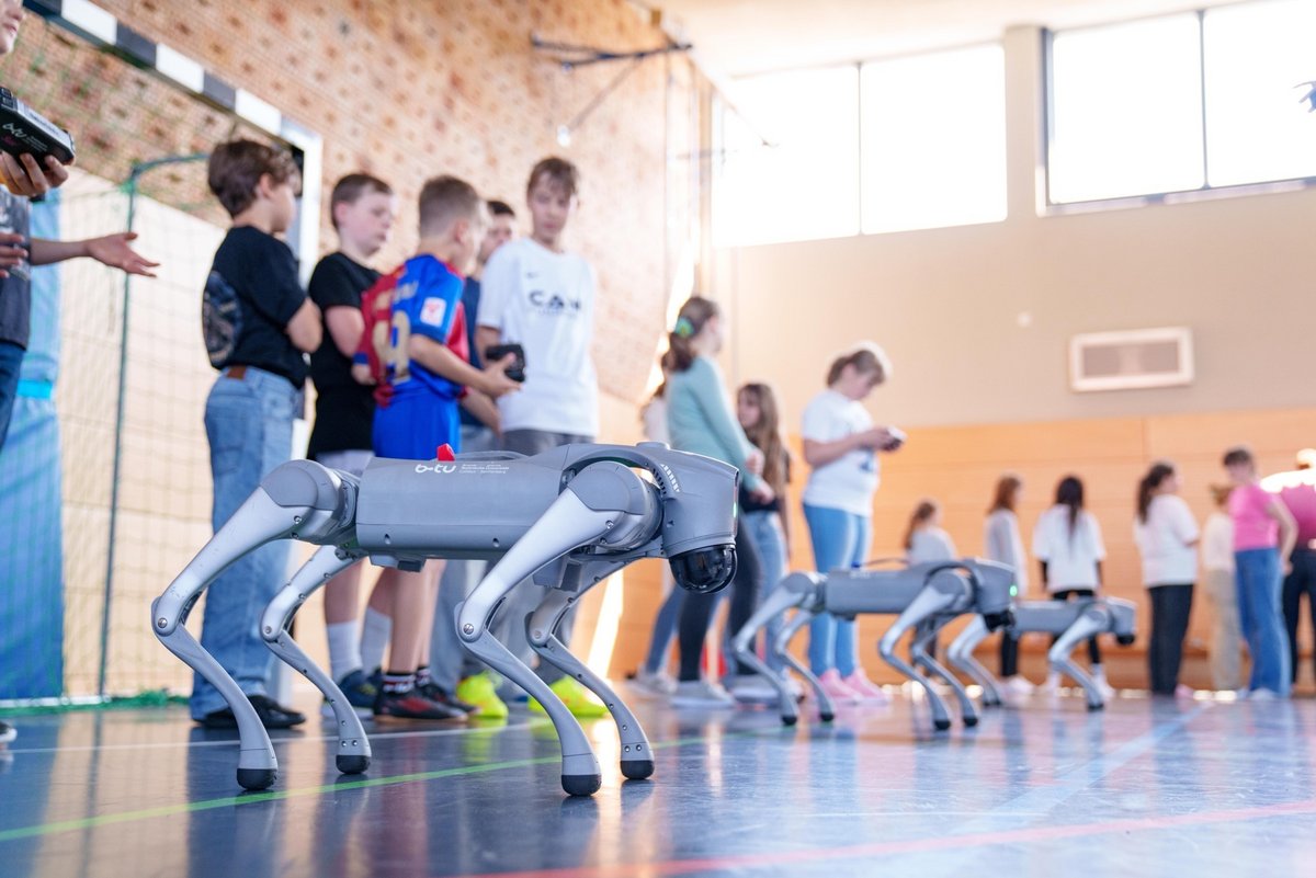 Pupils with three dog robots at the start of the course.