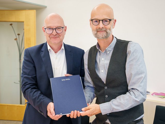 Die Unterzeichnenden mit dem Vertrag in der Hand