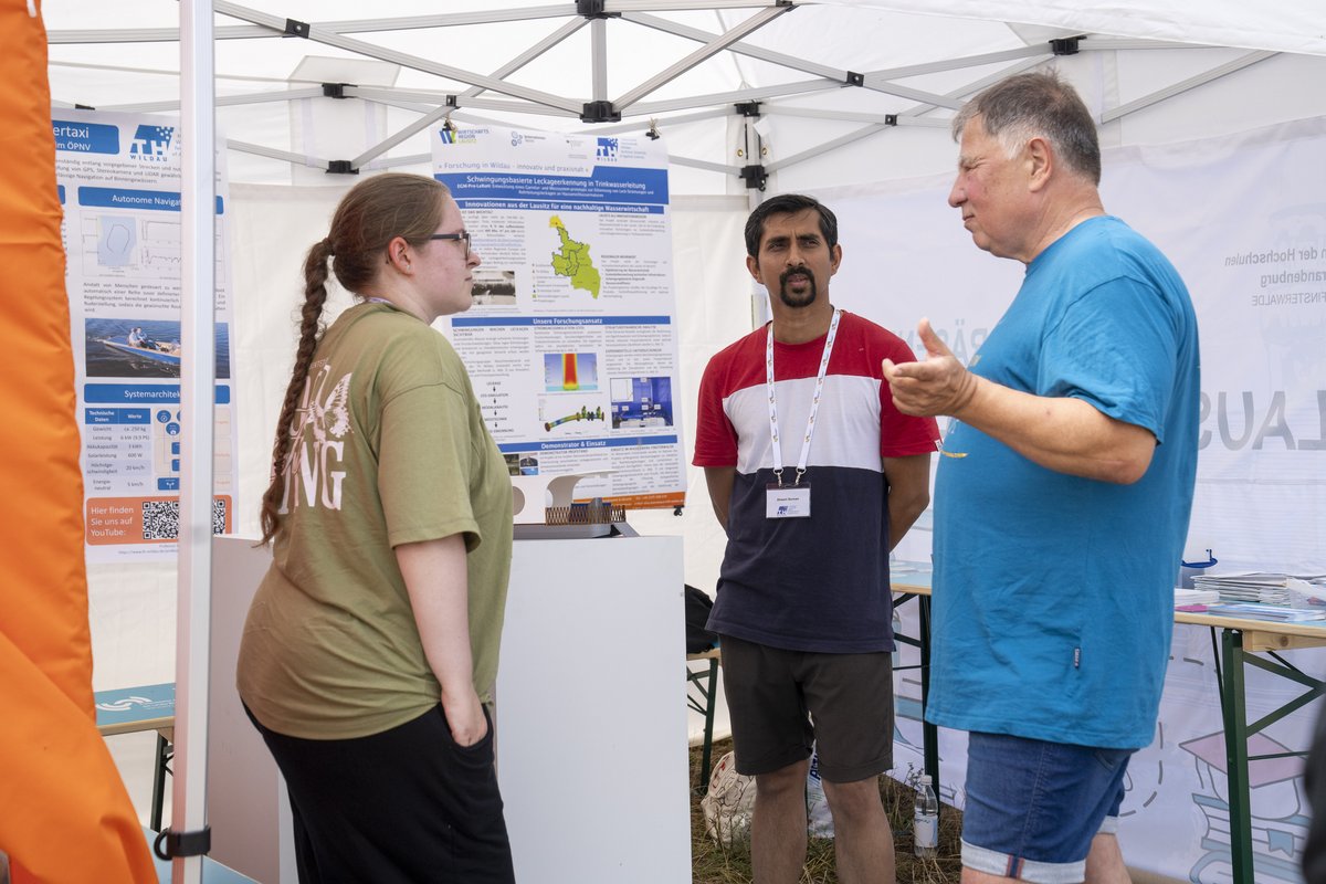 Ahsan Suman (TH Wi) testete das Gehör der Besuchenden: bei einem Klangspiel sollten sie aus mehreren Klangplatten den korrekten C-Ton heraushören. Die anderen Platten wiesen kleine Schäden auf, die ihr Schwingungsverhalten veränderten und hörbar machten, wie Verschleiß technische Bauteile beeinflusst. Ein ähnliches Verfahren wird auch bei dem von ihm vorgestellten Projekt EaST genutzt. Das Projekt läuft gemeinsam mit der Schönborner Armaturen GmbH und erforscht, wie Lecks in Wasserleitungen schneller erkannt werden können. Jeannette Amrhein (TH Wi) erklärte das Modell der autonom fahrbaren Solarfähre WIFAIR (© R. Schuster)