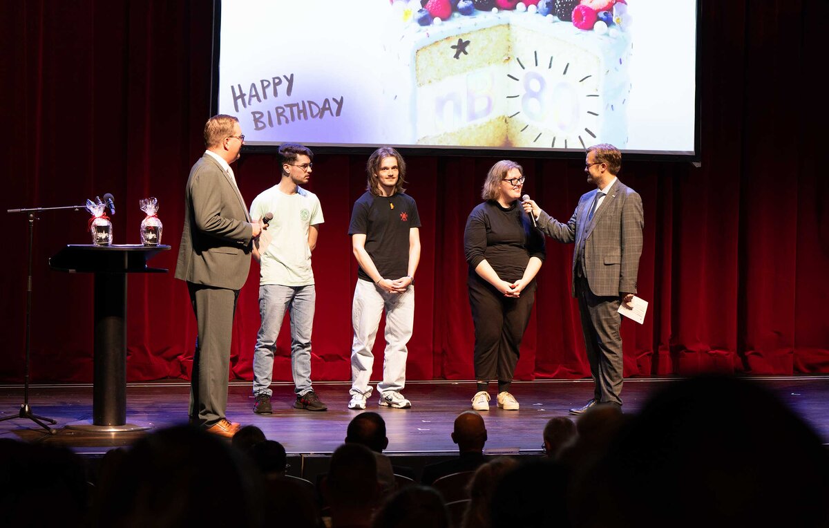 Landrat Alexander Erbert (links) und Bürgermeister Andreas Pfeiffer (rechts) mit Studierenden auf der Theaterbühne.