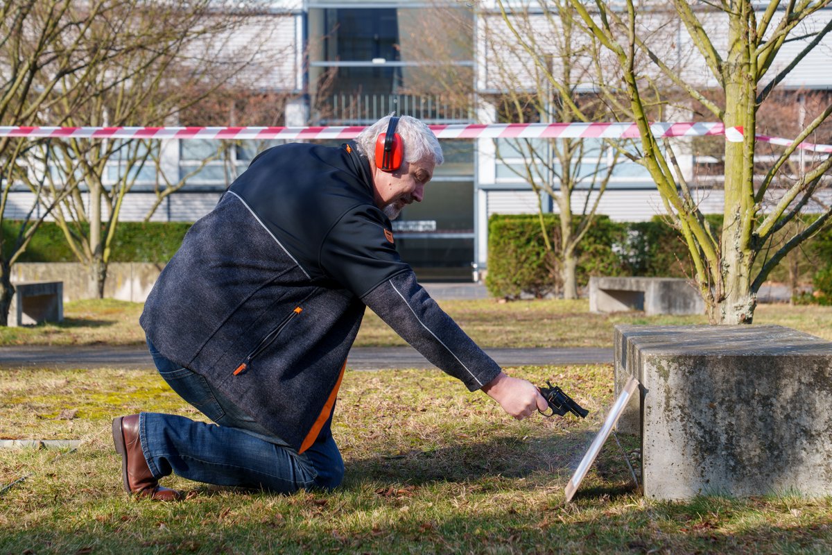 Professor Fischer schießt aus geringem Abstand auf das Ziel aus Papier. Foto: BTU, Sascha Thor.