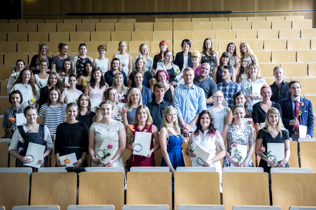 Absolventinnen und Absolventen des Studiengangs Soziale Arbeit im Hörsaal stehend. 