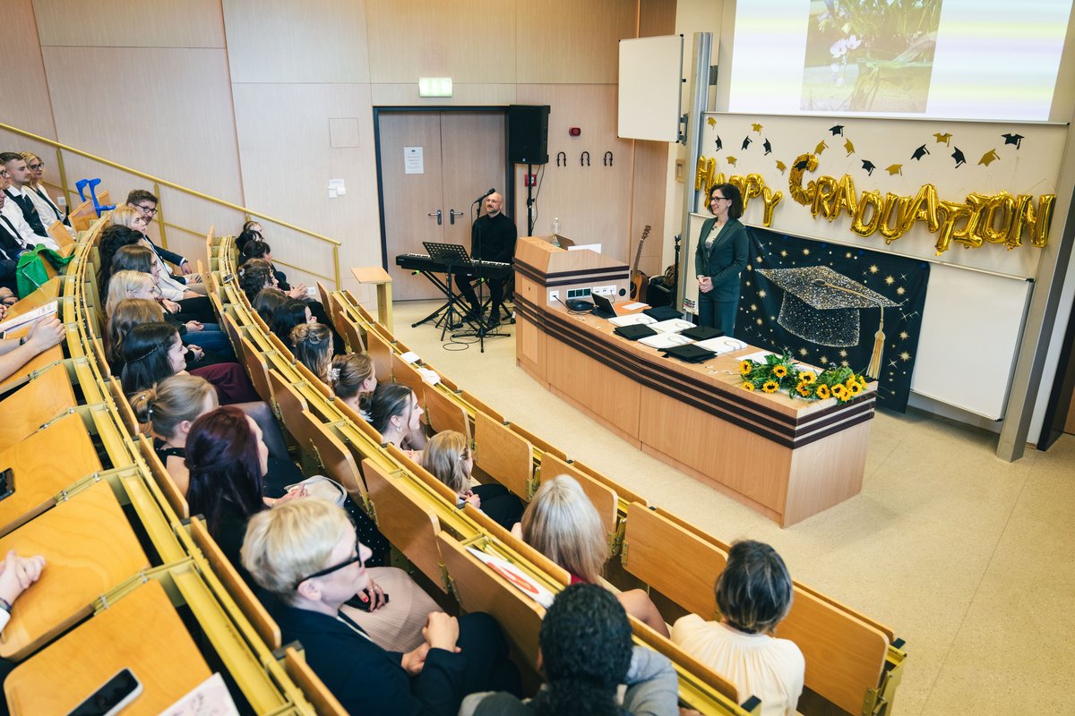 Hörsaal mit Professorin am Rednerpult