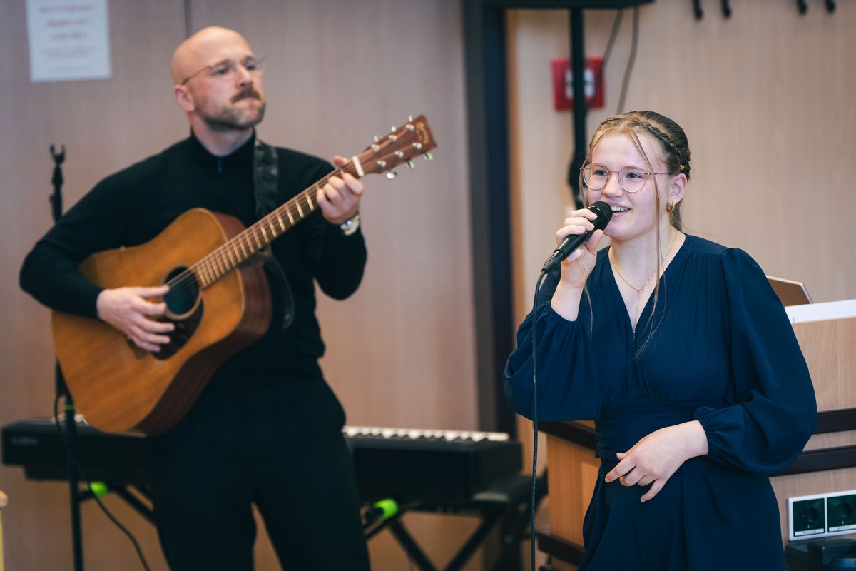Mann mit Gitarre und Frau am Mirkofon