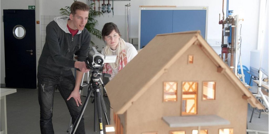 Filmen eines modellierten kleinen Holzhauses mit Lichtinstallation 