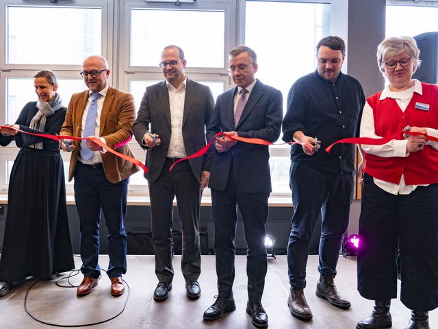 Group picture with red ribbon on stage