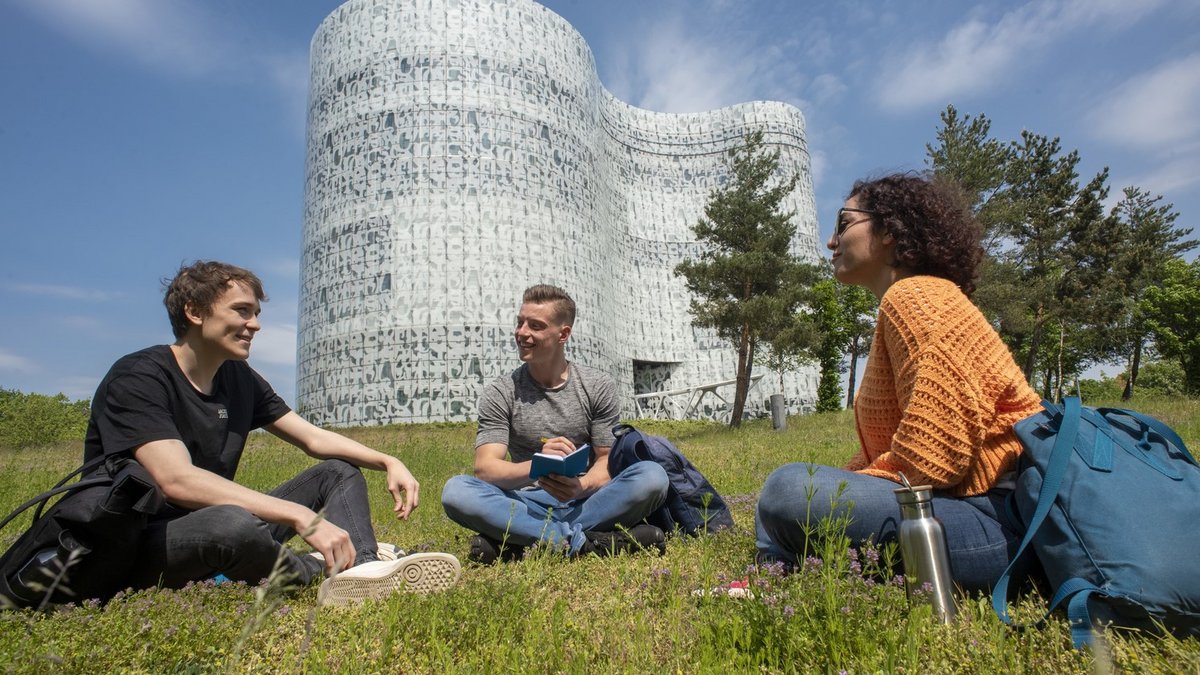Studierende auf der Wiese vor dem IKMZ