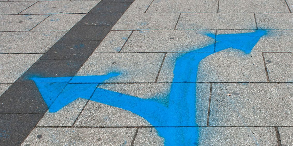 auf den Boden gemalte blaue Pfleile zeigen nach links und rechts