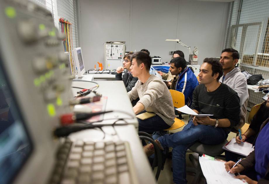 Austauschstudierende führen eine Übung mit elektronischen Messgeräten durch.