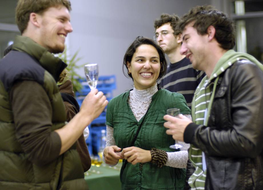 Gruppe lachender Personen bei einer universitären Abendveranstaltung