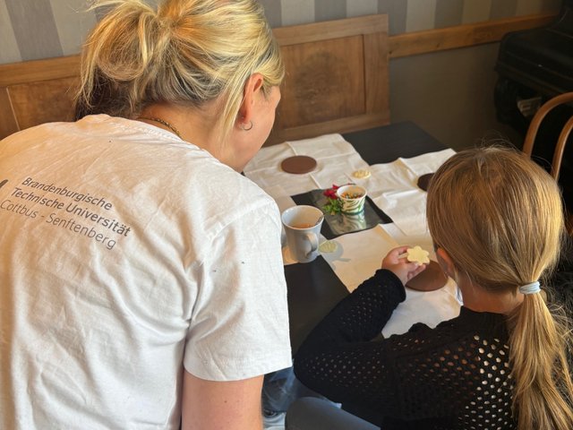 A carer helps a girl with her drawing