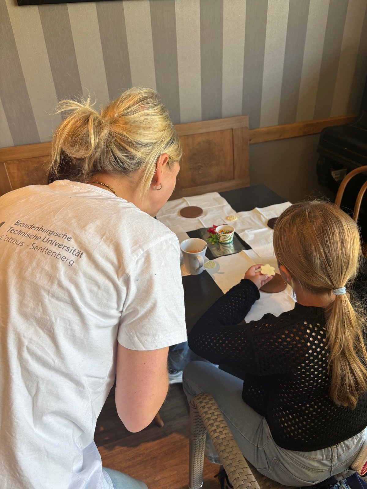 A carer helps a girl with her drawing