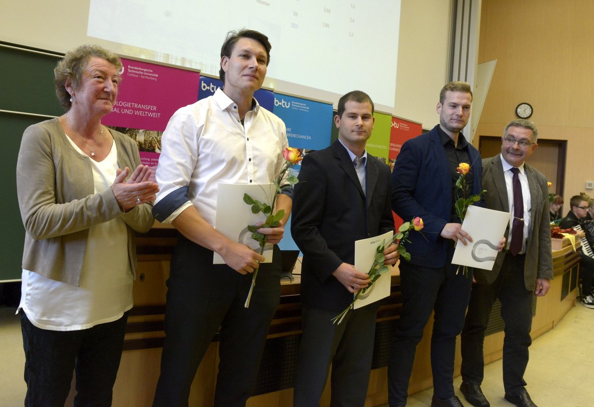 Master aus der Elektrotechnik neben Prof. Dr. Kathrin Lehmann (li.) und Prof. Dr. Erhard Stein (re.) stehend.