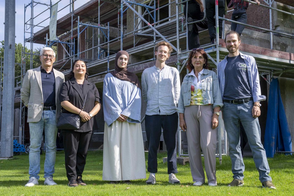 Prof. Dr.-Ing. Angelika Mettke mit ihrem Team beim Richtfest - vor dem Erweiterungsbau des Mehrzweckgebäudes in Kolkwitz stehend.