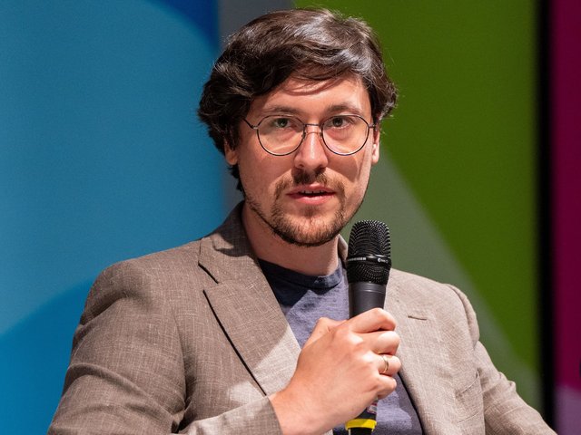Dr. Marius Klug spricht in ein Mikrofon.