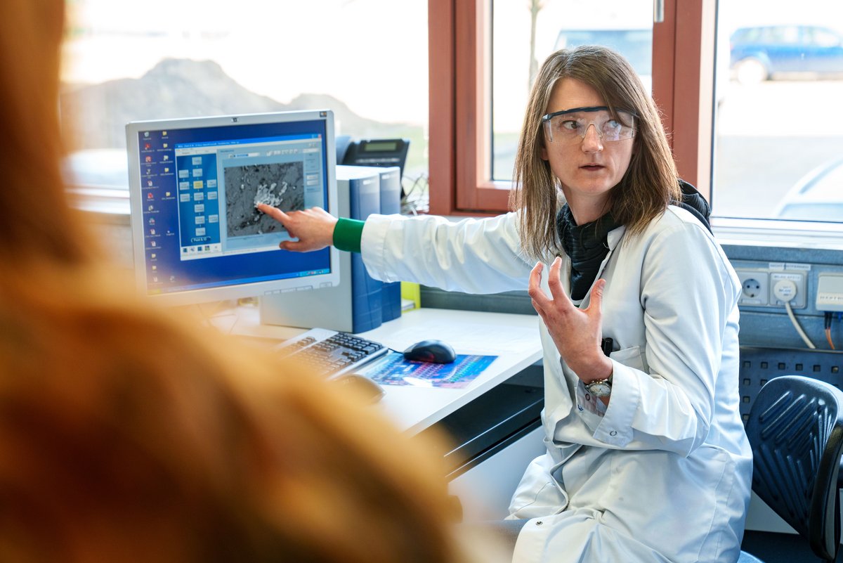 Chemielaborantin Mandy Turski erklärt, wie sich auf dem Bild des Rasterelektronenmikroskops Schmauchspuren erkennen lassen. Foto: BTU, Sascha Thor.