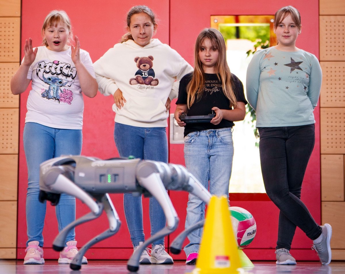 Team of four girls behind a robot controlled by him. 