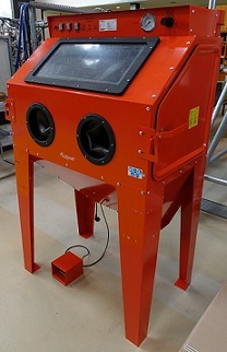 Orangene Unicraft Sandstrahlkabine SSK 2.5 zur Oberflächenvorbehandlung metallischer, Kunststoff- und Compositebauteile