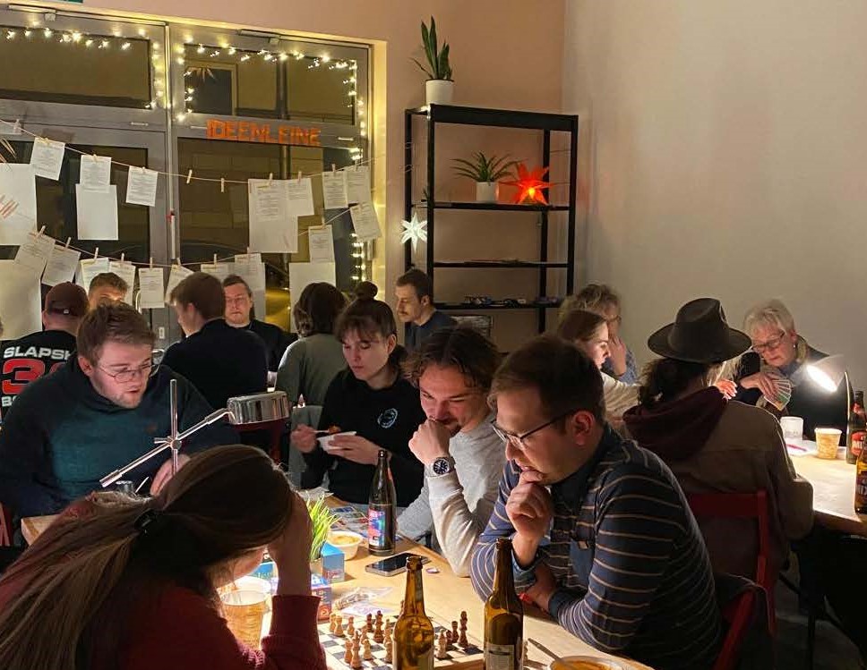 Blick in den Raum mit Menschen an Spieltischen