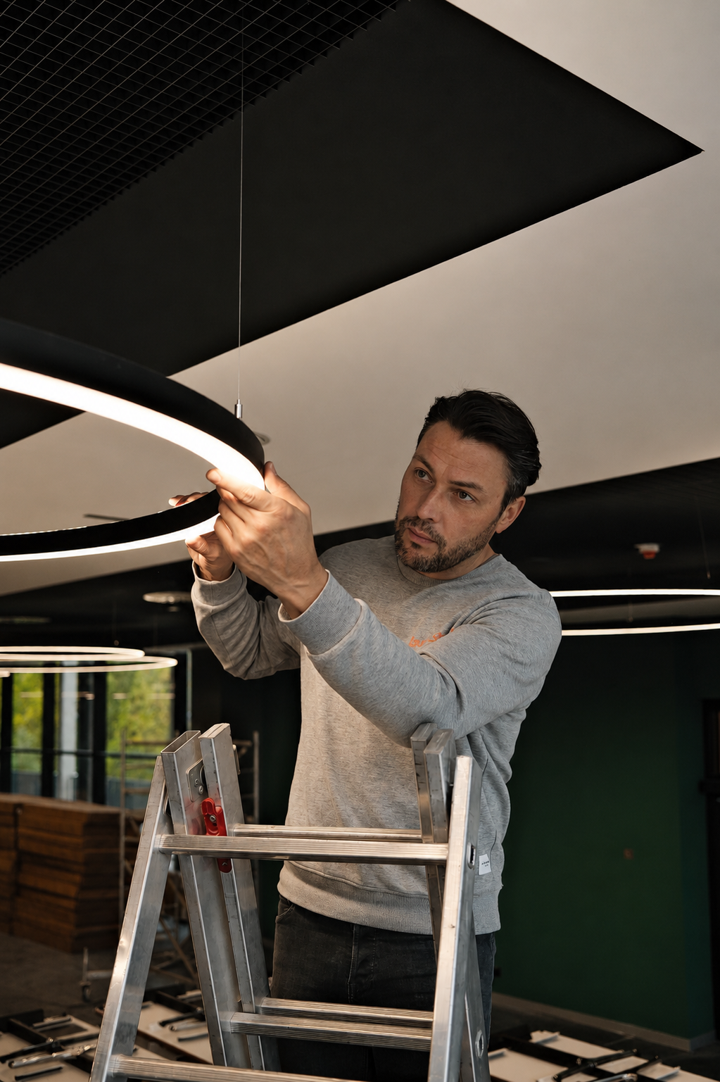 Stefan Restemeier (leuchtstoff*) bei der Installation seiner Leuchten in der Mensa. Foto: leuchtstoff