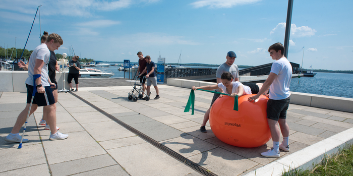 Das Foto zeigt Studierende der Physiotherapie, die Übungen am Seehafen Senftenberg demonstrieren. 