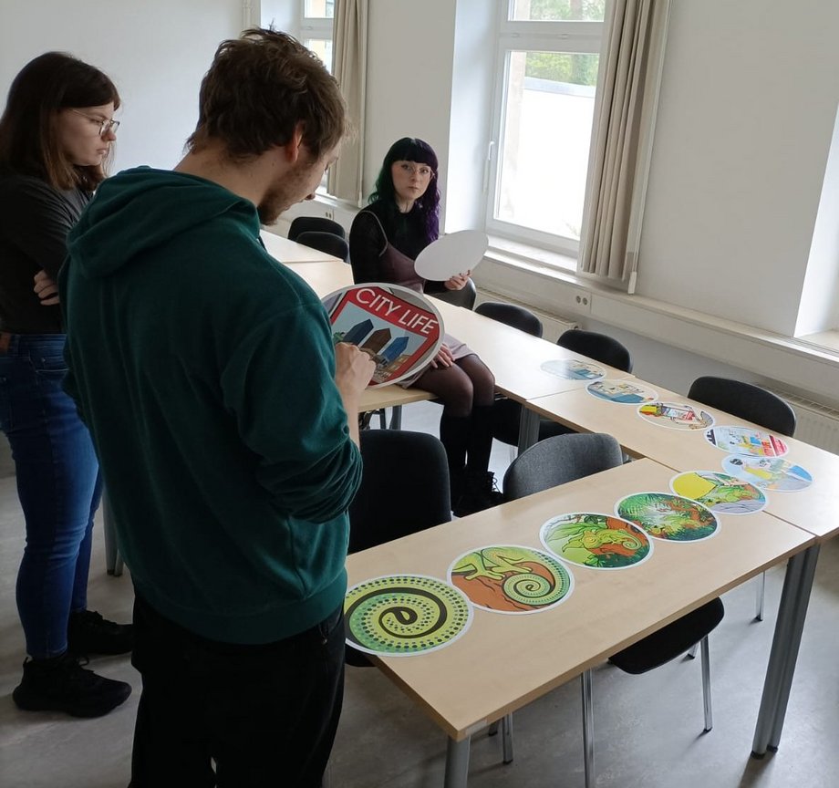 Die Grafik zeigt das Foto einer Seminargruppe während der Übung "Reality Check".