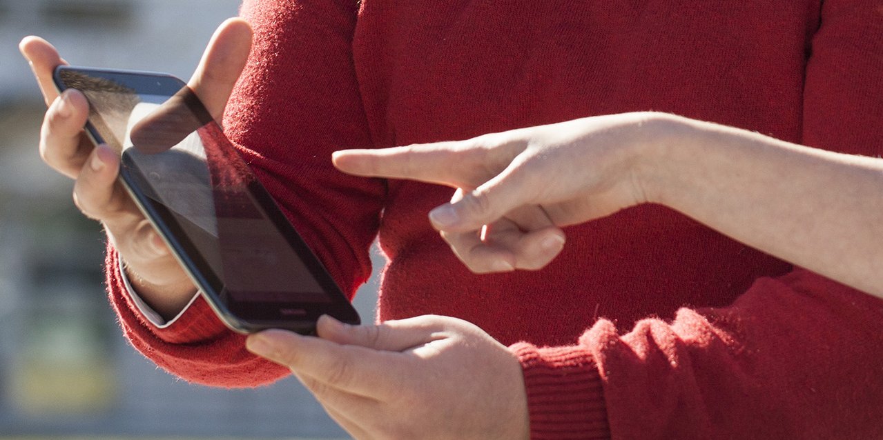 A person shows something to another person on a tablet