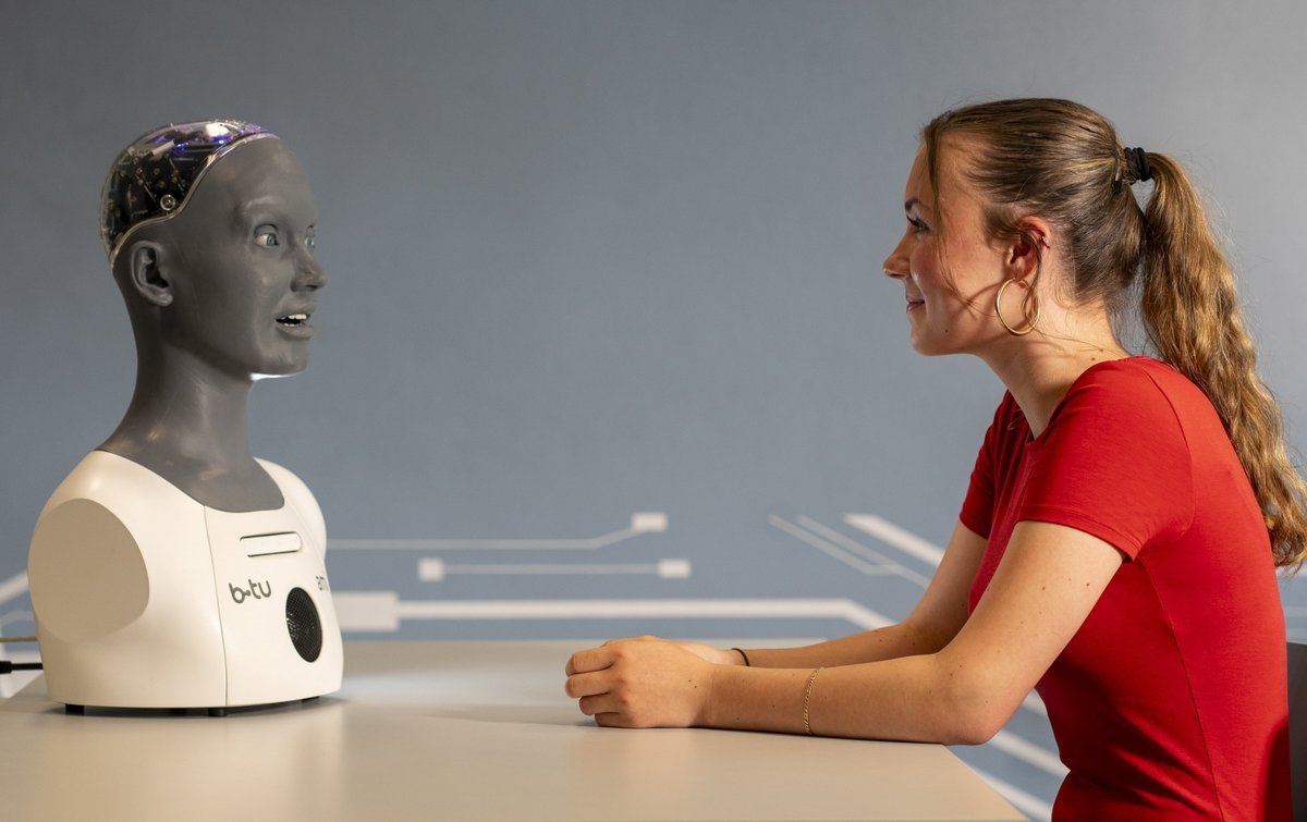 Mädchen im Gesprräch mit einem humanoiden Roboter.