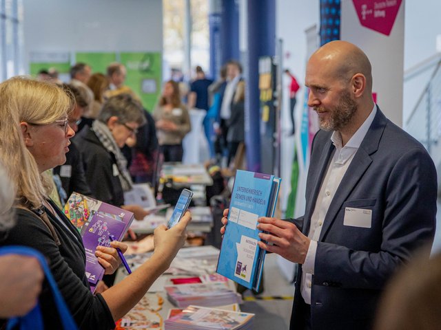 Im Bildungsforum diskutieren Aussteller*innen mit Tagungsteilnehmer*innen.