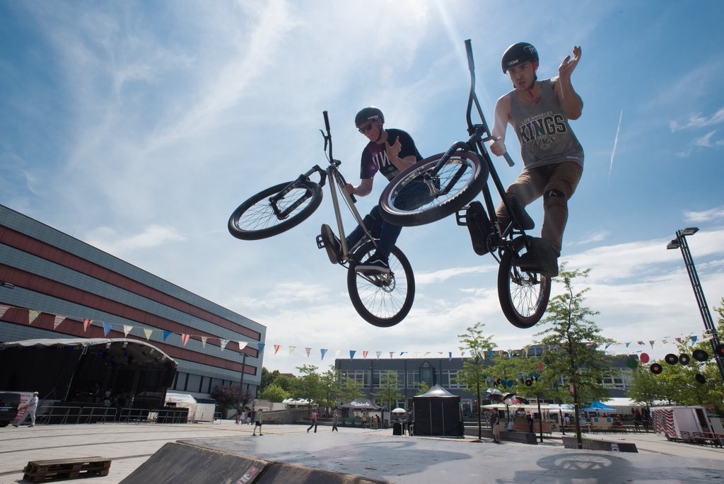 Studierende springen mit einem BMX-Fahrrad über eine Rampe