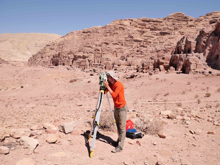 Ein Studierender steht am Vermessungsgerät in der Stadt Petra