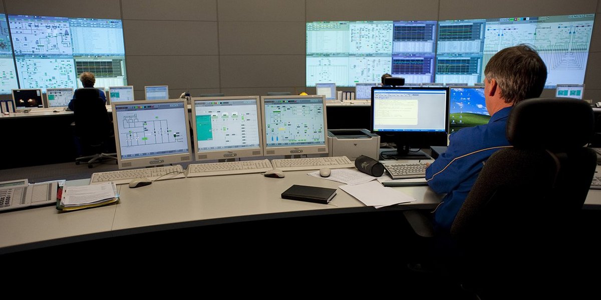 Control centre with many screens on which electrical circuit diagrams can be seen.
